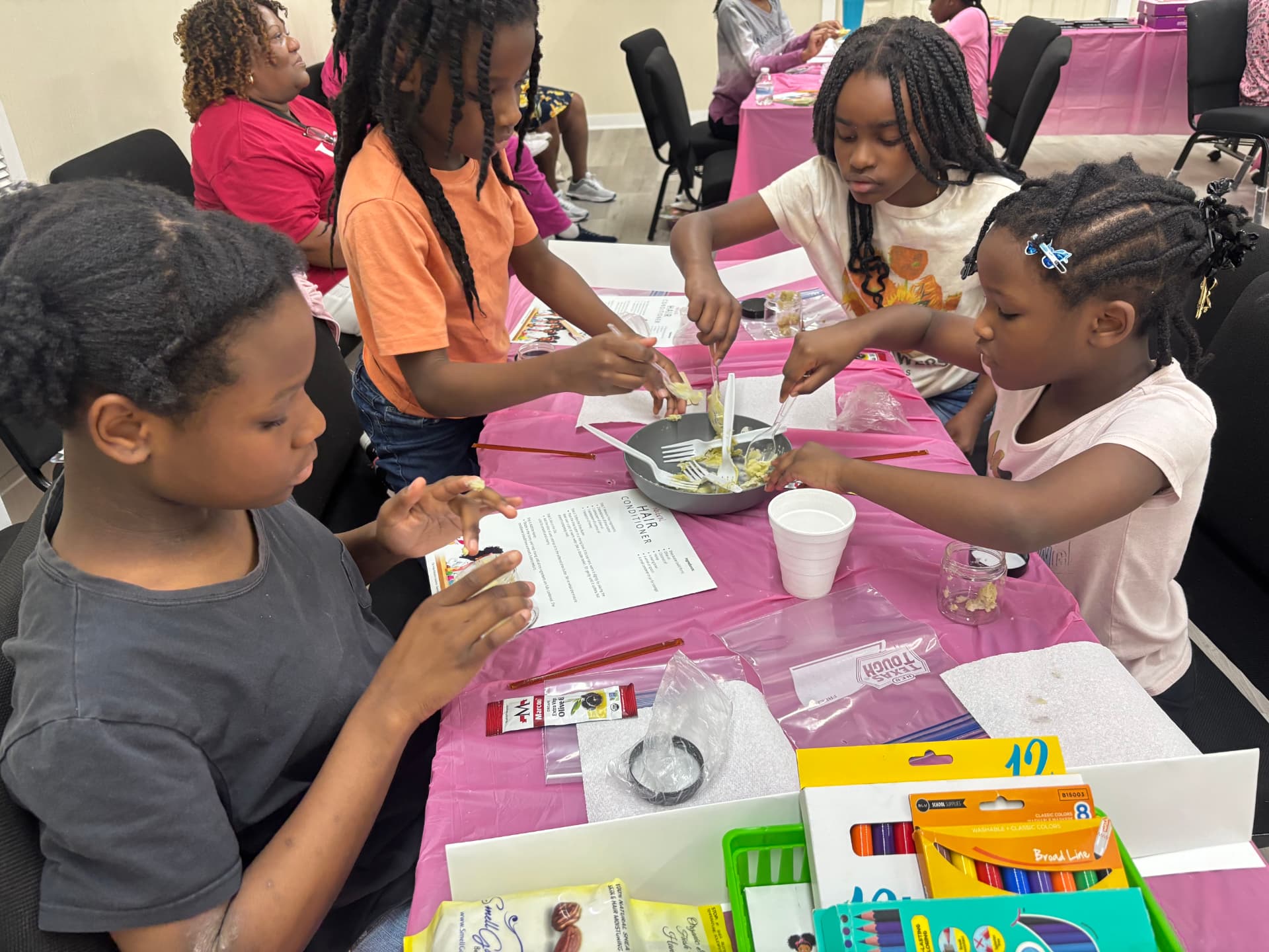Students mixing their own natural hair conditioner at a Beauty of STEM hands-on lab table